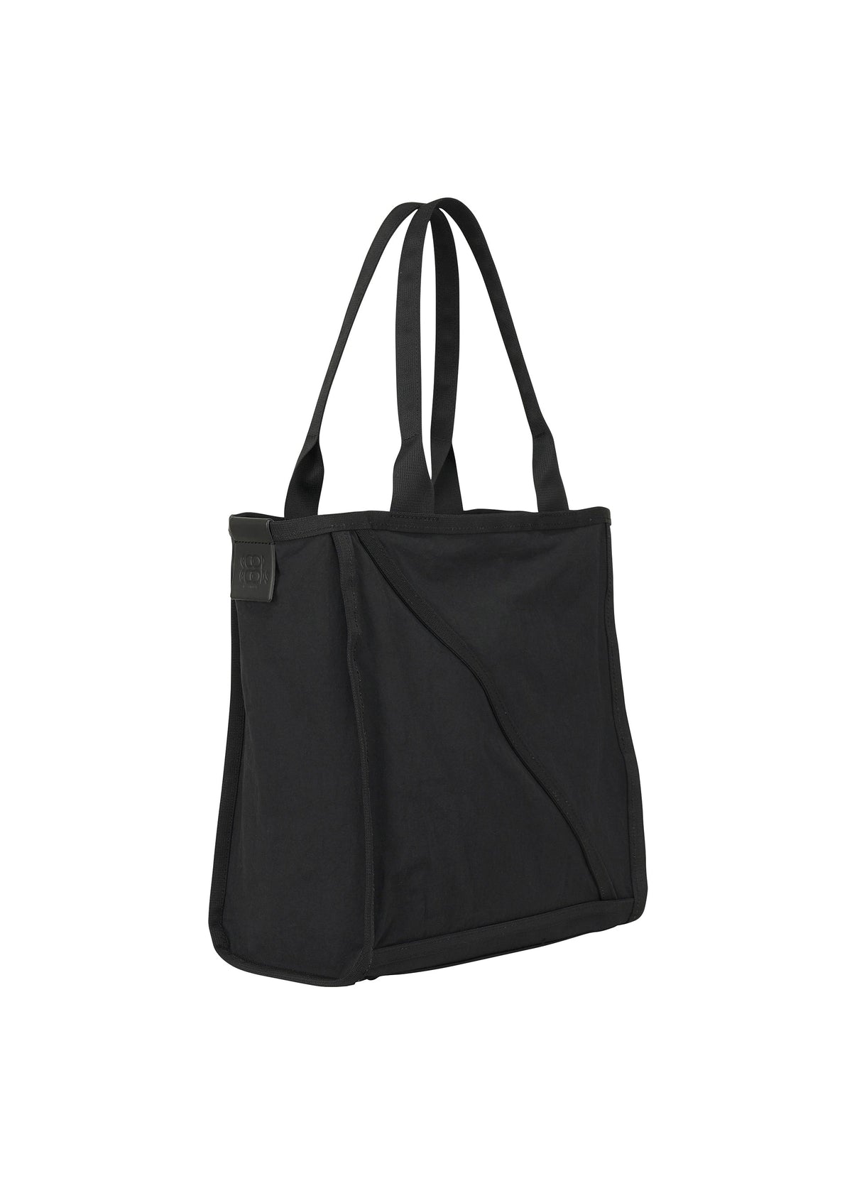 The WAKU tote bag by GOOD GOODS ISSEY MIYAKE is black, with two long straps and a slightly structured rectangular shape. It features wide gussets for extra space and a small patch accent, shown against a white background. view 2 of 6