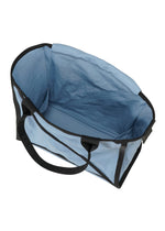 The WAKU tote by GOOD GOODS ISSEY MIYAKE is a large, empty, light blue fabric bag with black handles, wide gussets, and black trim, shown from above against a white background.