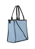 The WAKU tote by GOOD GOODS ISSEY MIYAKE is light blue with black edging and handles, an angular black seam design on the front, and wide gussets for extra capacity.