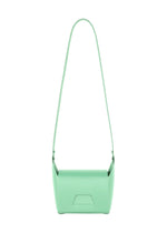 The BOX by GOOD GOODS ISSEY MIYAKE is a minimalistic mint green rectangular bag with a long strap, showcased against a white background.
