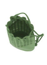 The MOKKO KNAPSACK by GOOD GOODS ISSEY MIYAKE is a green woven bag with a wavy top, short handles, adjustable shoulder strap, and drawstring closure; shown from above to highlight its spacious open interior.