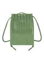 The MOKKO KNAPSACK by GOOD GOODS ISSEY MIYAKE is a green drawstring backpack with a woven lattice upper and solid bottom, featuring green cords for a stylish, functional look.
