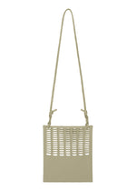 The MOKKO FLAP POUCH by GOOD GOODS ISSEY MIYAKE is a beige, square shoulder bag with side knots, cutout pattern on the upper front, and a long strap. This washable bag is shown against a plain white background.