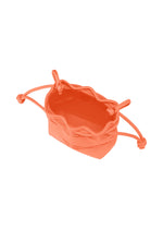 The MOKKO S.C. POCKET by GOOD GOODS ISSEY MIYAKE is a small orange knit fabric drawstring bag, shown from above with its top open and four drawstrings at the corners on a white background—washable and ideal for Spring Summer 2026.