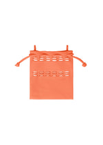 The MOKKO S.C. POCKET by GOOD GOODS ISSEY MIYAKE is a small orange knit drawstring bag with horizontal cutout patterns near the top, perfect for Spring Summer 2026, shown against a white background.