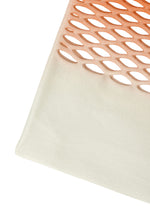 A close-up of the MOKKO NET GRADATION by GOOD GOODS ISSEY MIYAKE shows diamond-shaped cutouts in an orange gradient knit, seamlessly fading into solid cream fabric at the bottom.