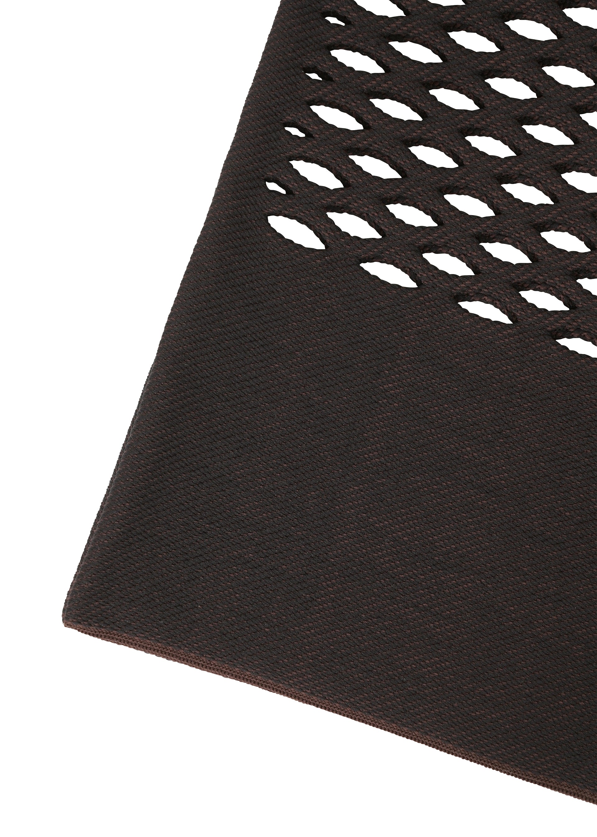 Zoomed view A close-up of the MOKKO BASKET by GOOD GOODS ISSEY MIYAKE shows its dark brown textured surface, resembling basket weave, with diamond-shaped cutouts forming a pattern in the upper right corner.