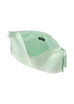 The ROLL by GOOD GOODS ISSEY MIYAKE is a light green, soft fabric crossbody bag with an elegant sheen, wide opening, adjustable side straps, and a black ICONICSON label. This lightweight bag is shown empty against a white background.