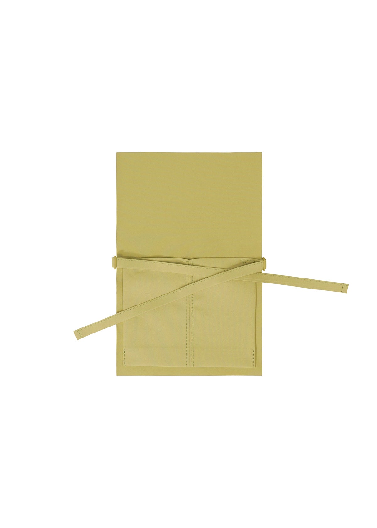 The GOOD GOODS ISSEY MIYAKE ROLL apron in beige or light yellow is shown laid flat on a white background, featuring a neck loop, two front pockets, and extended waist ties. view 3 of 7