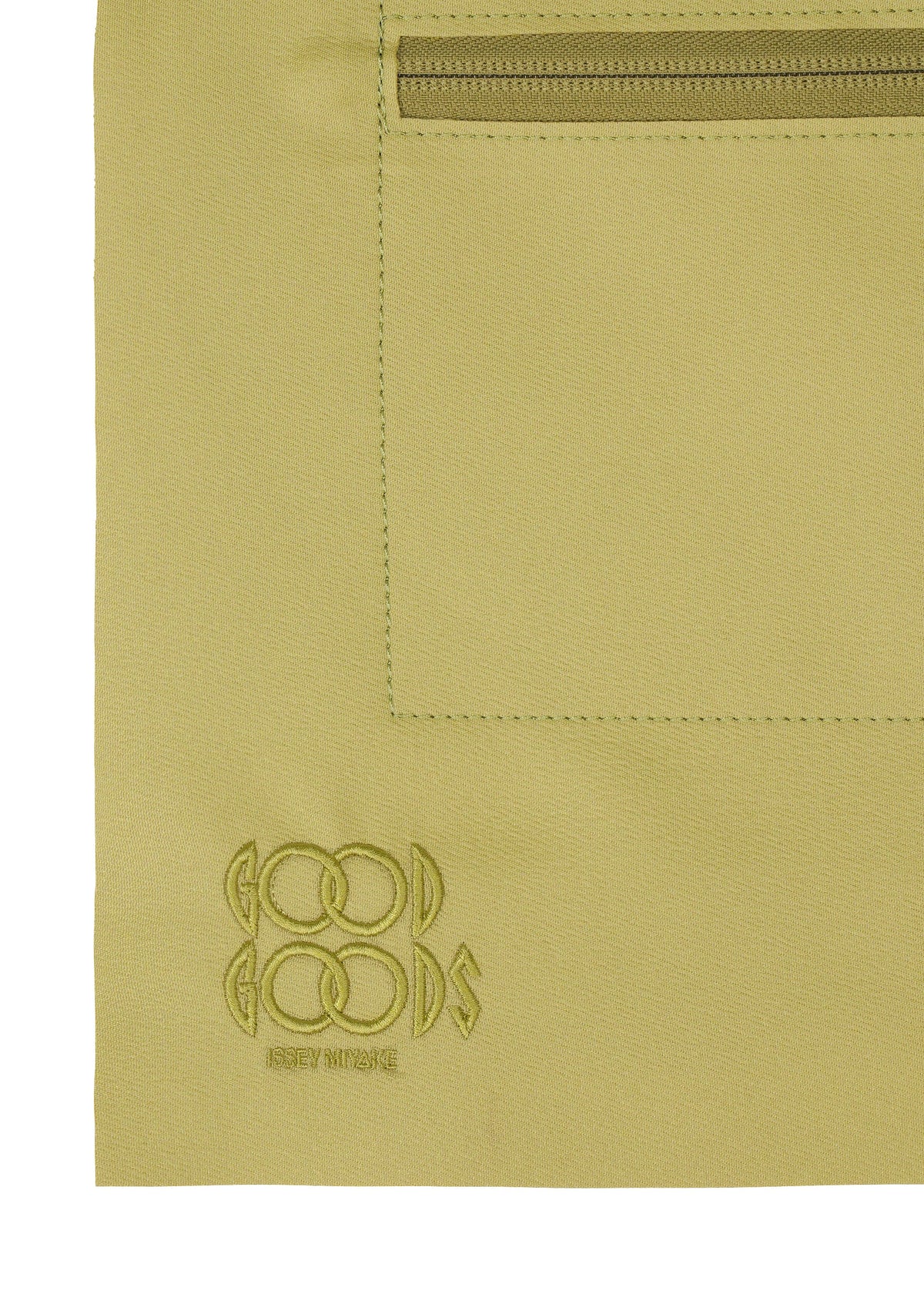 A close-up of the ROLL shoulder bag in khaki fabric by GOOD GOODS ISSEY MIYAKE, featuring a stitched rectangular pocket, top zipper, and an embroidered brand logo in the lower left corner. view 5 of 7