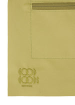 A close-up of the ROLL shoulder bag in khaki fabric by GOOD GOODS ISSEY MIYAKE, featuring a stitched rectangular pocket, top zipper, and an embroidered brand logo in the lower left corner.