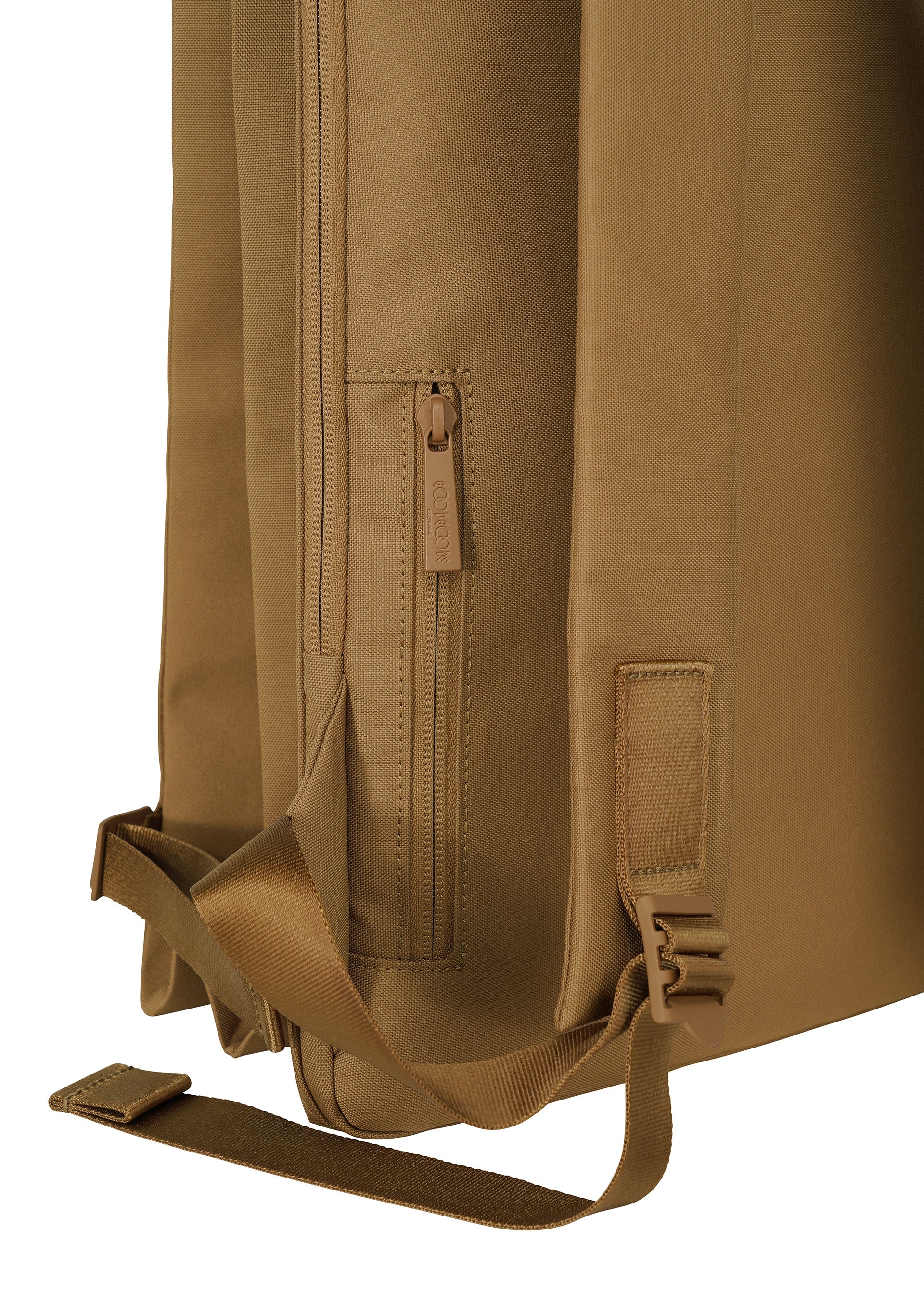 Zoomed view A close-up of the JABARA backpack by GOOD GOODS ISSEY MIYAKE in tan, highlighting its expandable design, zippered pocket with pull, adjustable shoulder strap with plastic buckle, and durable fabric for ample storage and daily use.