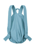 The FUWA FUWA by GOOD GOODS ISSEY MIYAKE is a light blue, soft backpack inspired by traditional Japanese workwear. It features padded, quilted shoulder straps and a simple, unstructured silhouette with a rounded bottom—embodying a thoughtful, zero-waste design philosophy.