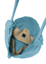 A top view of the open FUWA FUWA shoulder bag by GOOD GOODS ISSEY MIYAKE in light blue fabric, showcasing its beige inner lining with two inner pockets and a black label. The bag draws inspiration from traditional Japanese aesthetics and features a zero-waste design approach, as well as two distinctive knotted handles.