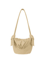 The FUWA FUWA shoulder bag by GOOD GOODS ISSEY MIYAKE is a beige accessory with a long strap and distinctive knotted details on each side; inspired by Japanese noragi, it showcases a gathered, pouch-like design on the front. - BEIGE （no.41）