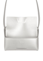 A minimalist white leather shoulder bag from GOOD GOODS ISSEY MIYAKE, the BOX features a structured, box-inspired silhouette with an open flap and an embossed logo on the front.