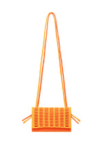 The MOKKO BI-COLOR by GOOD GOODS ISSEY MIYAKE is a small, rectangular orange knit bag with a grid-textured front, double long straps with side knots, washable fabric, and a minimalist modern design.