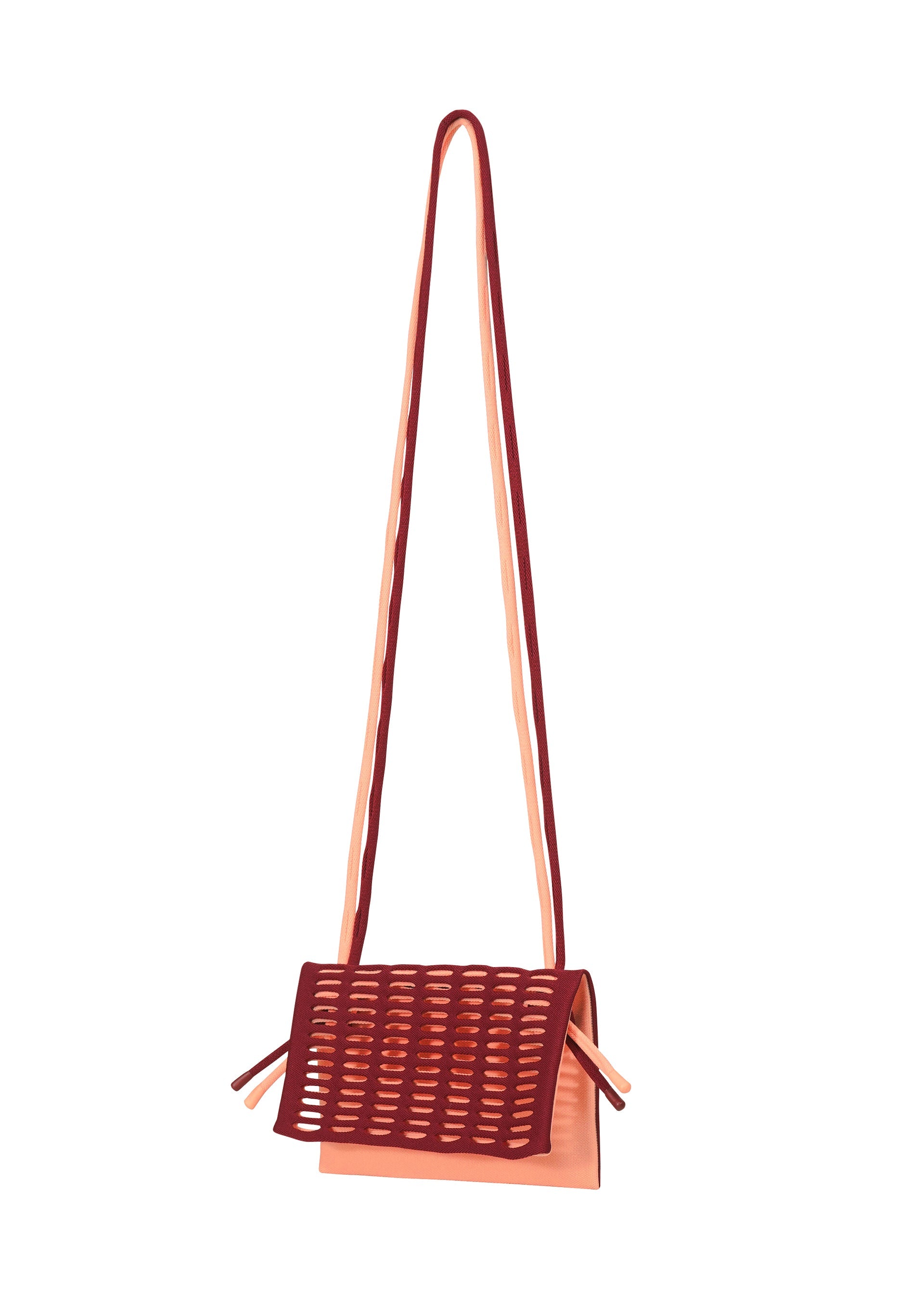 Zoomed view The MOKKO BI-COLOR by GOOD GOODS ISSEY MIYAKE is a small, peach tote with a long strap, maroon perforated flap, decorative slit patterns, and side ties. This washable bag offers a modern look.