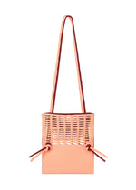 The MOKKO BI-COLOR by GOOD GOODS ISSEY MIYAKE is a peach-colored washable tote featuring top cut-out slits, two long shoulder straps, and side drawstring details.