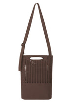 The MOKKO MONO GRIP by GOOD GOODS ISSEY MIYAKE is a brown tote bag featuring an adjustable shoulder strap and a distinctive cutout handle. The upper section showcases a grid-like arrangement of rectangular holes, while the lower portion is crafted from solid fabric. Ideal as a business bag, this versatile accessory is presented against a white background. - BROWN （no.44）