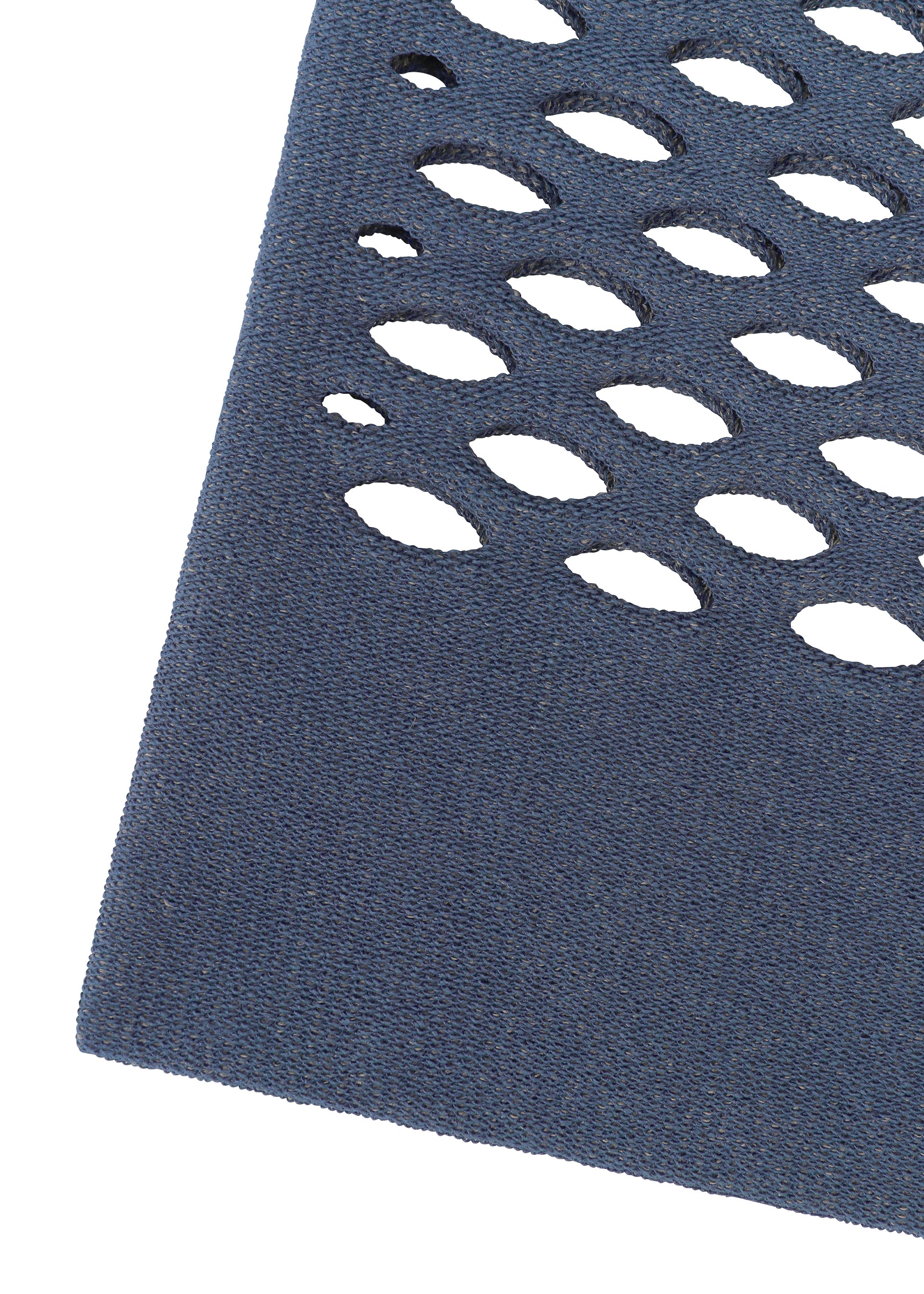Zoomed view Close-up of MOKKO WASHI by GOOD GOODS ISSEY MIYAKE, showing a dark blue textured surface with oval cut-out holes in rows, evoking a washi paper tote bag, set diagonally on a white background.