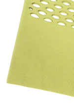 A close-up of yellow-green textured MOKKO WASHI fabric by GOOD GOODS ISSEY MIYAKE, showing oval cutouts near the edge—ideal for a summer shoulder bag—set against a white background.