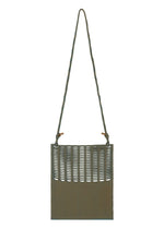 The MOKKO WALE by GOOD GOODS ISSEY MIYAKE is a rectangular olive-green woven shoulder bag with a long twisted strap and an open lattice-style upper section.