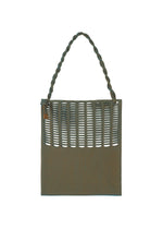 The MOKKO WALE by GOOD GOODS ISSEY MIYAKE is a rectangular green woven tote with vertical striped cutout slits on the front and a thick, twisted handle.