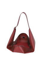 The LEAF by GOOD GOODS ISSEY MIYAKE is a red leather shoulder bag with a wide strap, suede-like lining, zip pocket, and smooth, modern angular design.