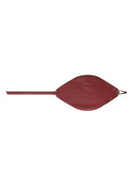 The LEAF by GOOD GOODS ISSEY MIYAKE is a red, leaf-shaped cross-body bag in suede-like fabric with a long strap and metal ring detail, shown on a white background.