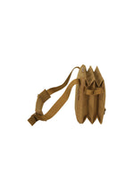 The JABARA shoulder bag by GOOD GOODS ISSEY MIYAKE is shown from the side against a white background. This tan bag features accordion pleats, an adjustable strap, three main compartments, and a dedicated laptop pocket.