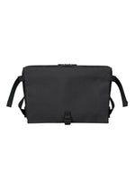 The JABARA messenger bag by GOOD GOODS ISSEY MIYAKE, shown against a white background, is a plain black design featuring a flap closure, adjustable shoulder strap, side straps, and an interior laptop pocket for added convenience. - BLACK （no.15）