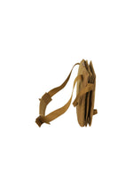 The JABARA shoulder bag by GOOD GOODS ISSEY MIYAKE is shown in tan from the side, isolated on a white background. It features an adjustable shoulder strap, multiple compartments including a dedicated laptop pocket, and distinctive accordion pleat detailing.