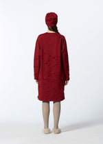 A person faces away, wearing HaaT's 3D△ KNIT long red wool-blend dress with cut-out details, a matching red hat, beige tights, and fluffy slippers against a plain white background.