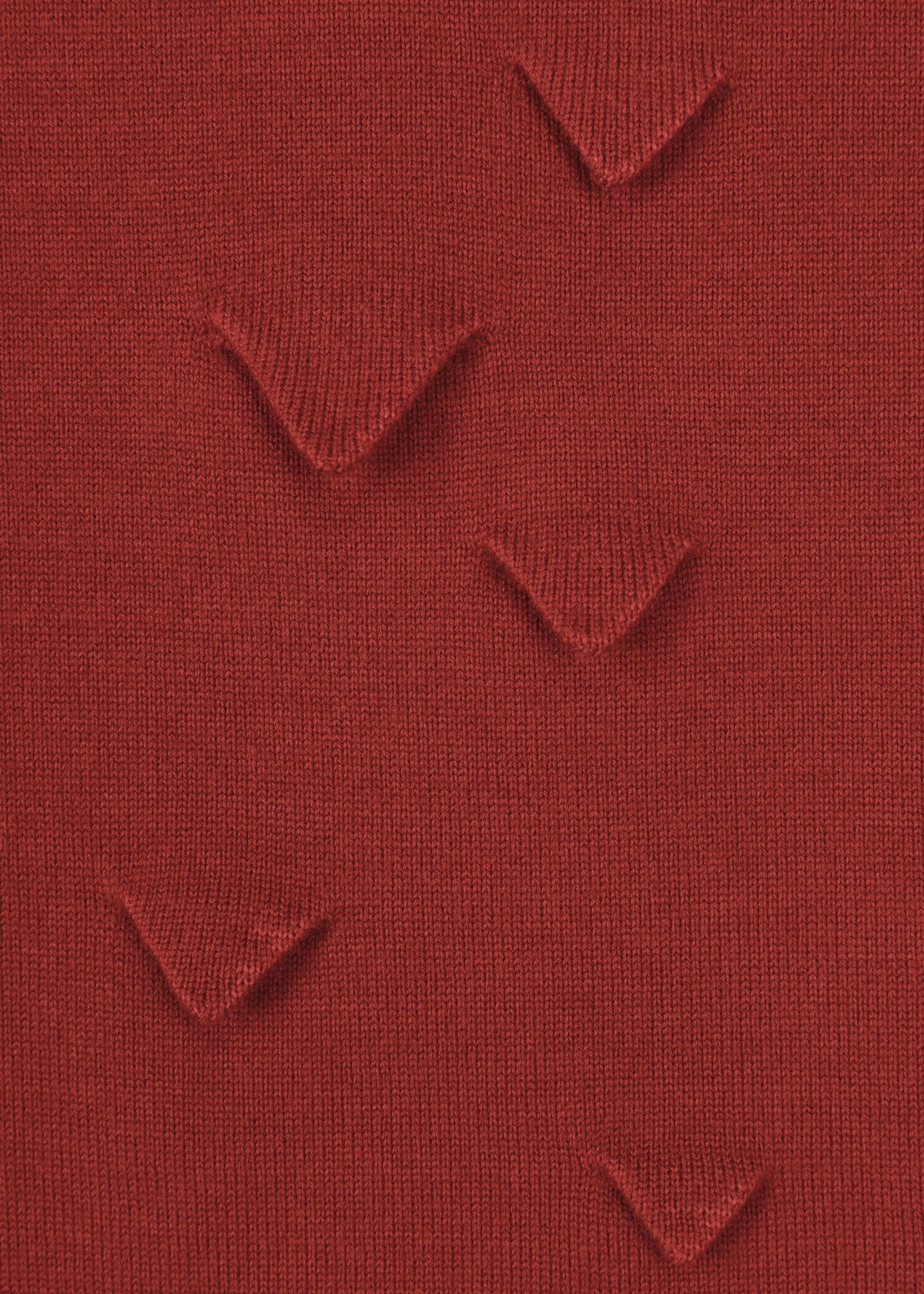 Close-up of HaaT’s 3D△ KNIT: a red wool-blend fabric with five raised V-shaped folds, crafted using short-row knitting for an evenly spaced, textured 3D pattern. view 6 of 9