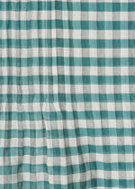 Close-up of HaaT’s 2 SIDE PINTUCKING stole in green and white checks, showing cotton silk fabric with slight wrinkles and creases that add texture and gentle pattern distortion.