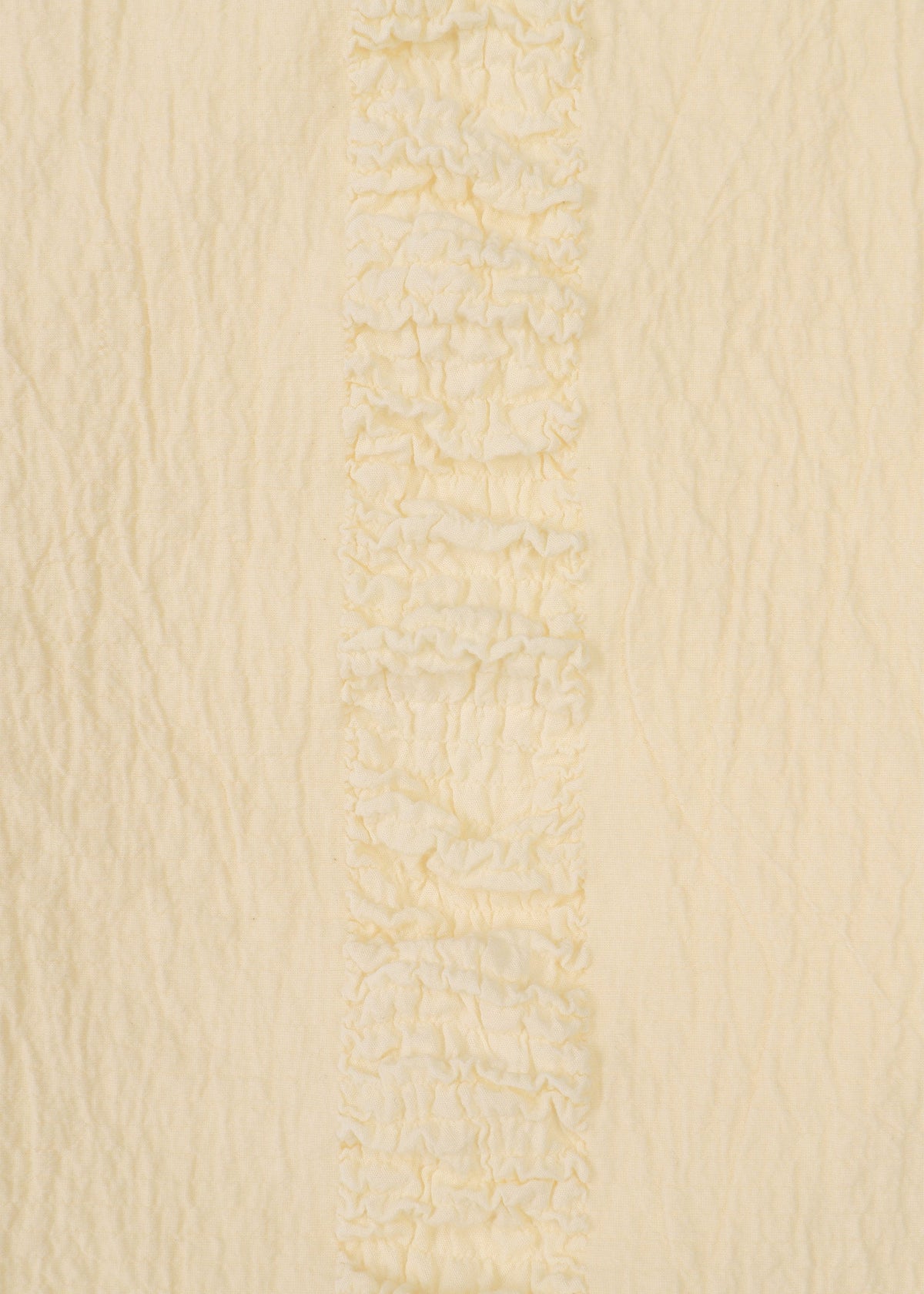 A close-up of HaaT's TENMOKU COTTON in cream shows gently wrinkled, soft garment-dyed fabric with a vertical textured ruffled stripe—ideal for a sleeveless top with subtle detailing. view 5 of 8