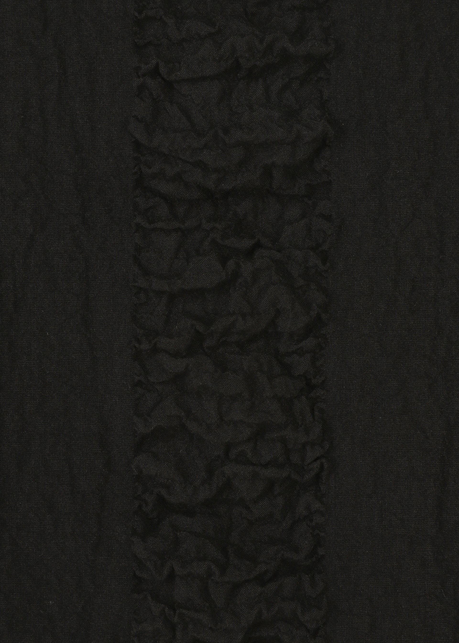 Zoomed view Close-up of HaaT's TENMOKU COTTON: textured black fabric with a vertical ruffled stripe and a mottled pattern inspired by Tenmoku glaze, contrasted by smoother fabric on each side.
