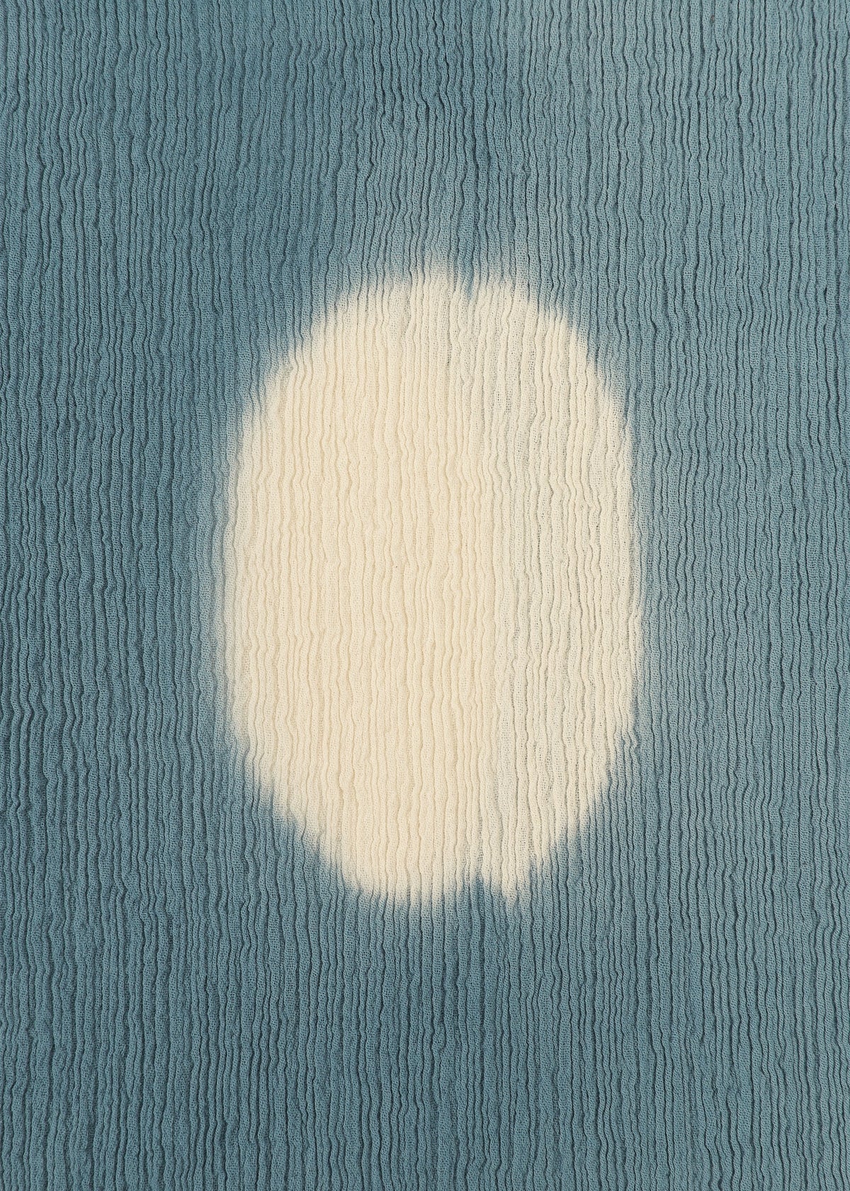 The KYO CHIJIMI ITAJIME by HaaT features a textured blue surface with a large, irregular white circle at the center, evoking Itajime dyeing on handcrafted skirts, set against a wavy ridged background. view 6 of 9
