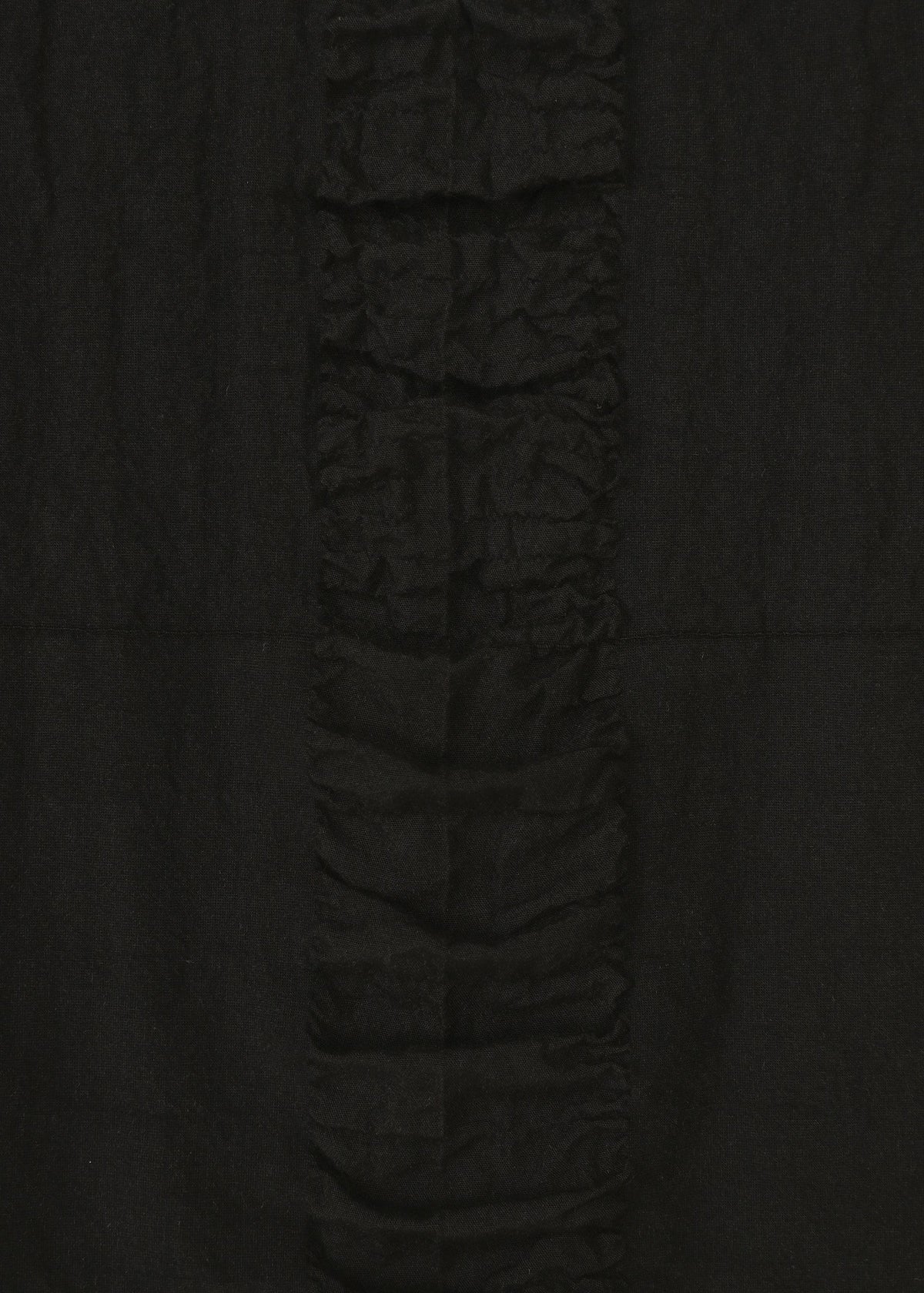 A close-up of HaaT’s TENMOKU COTTON skirt fabric features a garment-dyed, textured surface with a central vertical ruffle, highlighting rich textures and creases against a smooth background. view 4 of 7