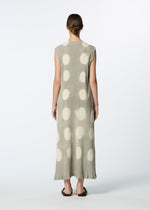 A person with short hair stands facing away, wearing the HaaT KYO CHIJIMI ITAJIME sleeveless, ankle-length handcrafted dress with large white polka dots and black sandals, photographed against a plain white background.
