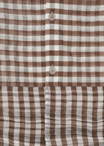 Close-up of HaaT's 2 SIDE PINTUCKING dress featuring a brown and white gingham pattern, vertical buttons, and horizontal pleats at the hem for a stylish contrast between smooth and pleated textures.