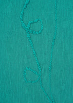 HaaT’s KYO CHIJIMI EMB features teal crinkled fabric with Garabo thread embroidery creating a vertical vine and three simple leaves.