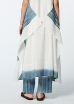 A model wears the HaaT SAZANAMI white organic cotton tunic with blue-striped panels on the back and hem, paired with matching blue-striped pants and black sandals, shown from behind against a plain background.