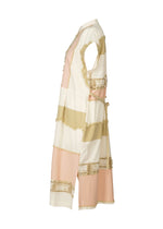 Side view of HaaT’s KASANEGAKE, a sleeveless, knee-length jacquard dress with wide cream, beige, and light pink stripes. Decorative fringe and ribbons add textured detail to the layered design shown on a white background.
