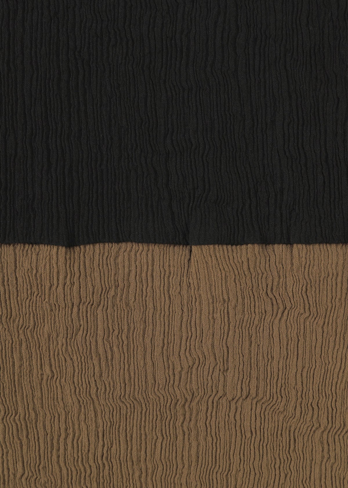 The HaaT KYO CHIJIMI STREAM features textured fabric with horizontal, crinkled lines and two-tone color blocking: black on the upper half and brown on the lower half. view 3 of 6