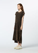 A person with long, wavy red hair wears the HaaT TENMOKU COTTON loose dark brown textured dress with short sleeves and frayed edges, paired with white sneakers, standing against a plain light background.