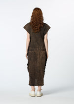 A person with long curly hair, dressed in HaaT's TENMOKU COTTON brown textured garment-dyed dress and white shoes, stands facing away from the camera against a plain white background.