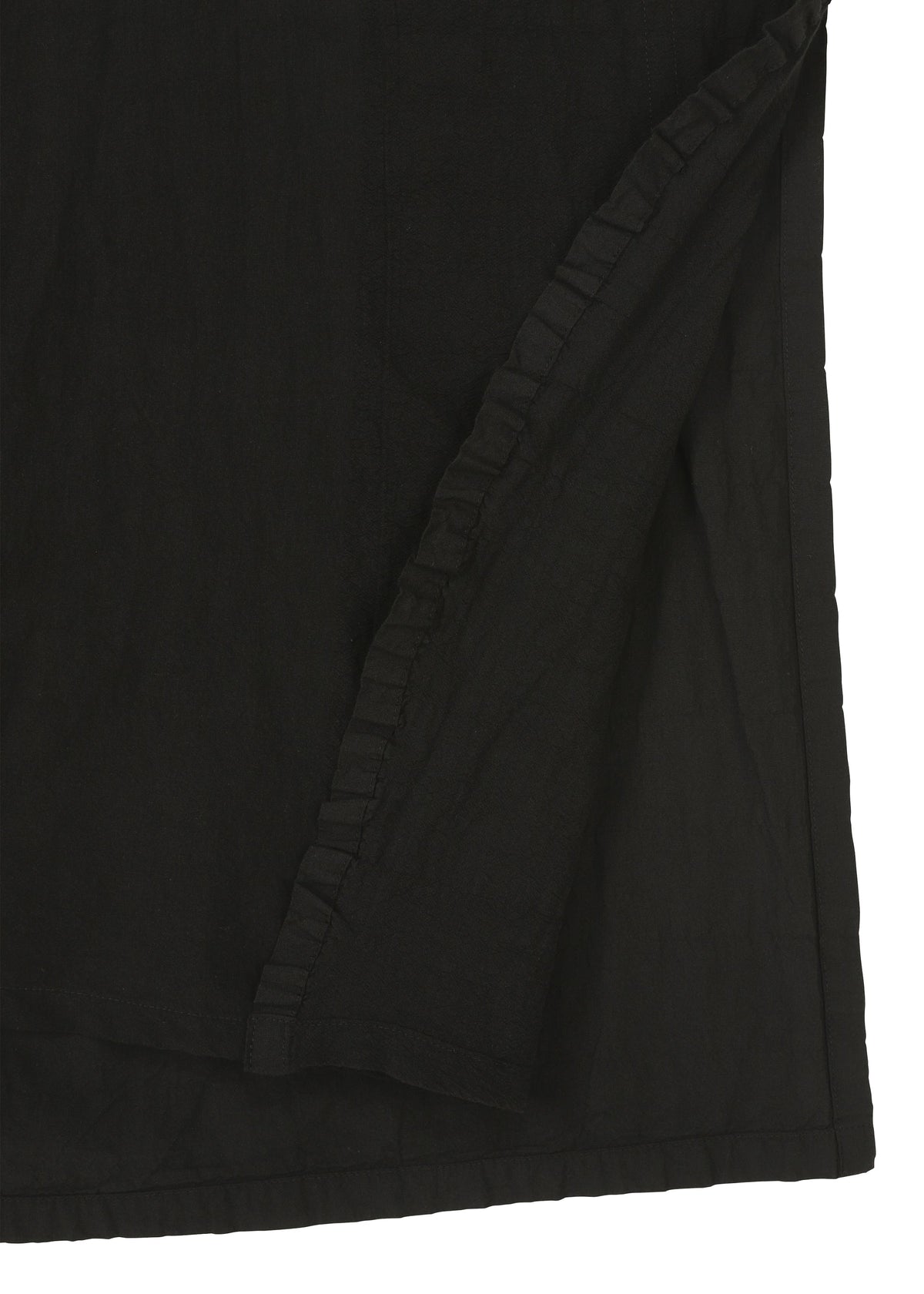 Close-up of TENMOKU COTTON by HaaT, a black fabric with a folded corner and ruffled edge. The smooth, subtly textured surface displays slight variations, reminiscent of garment-dyeing for added depth. view 4 of 7