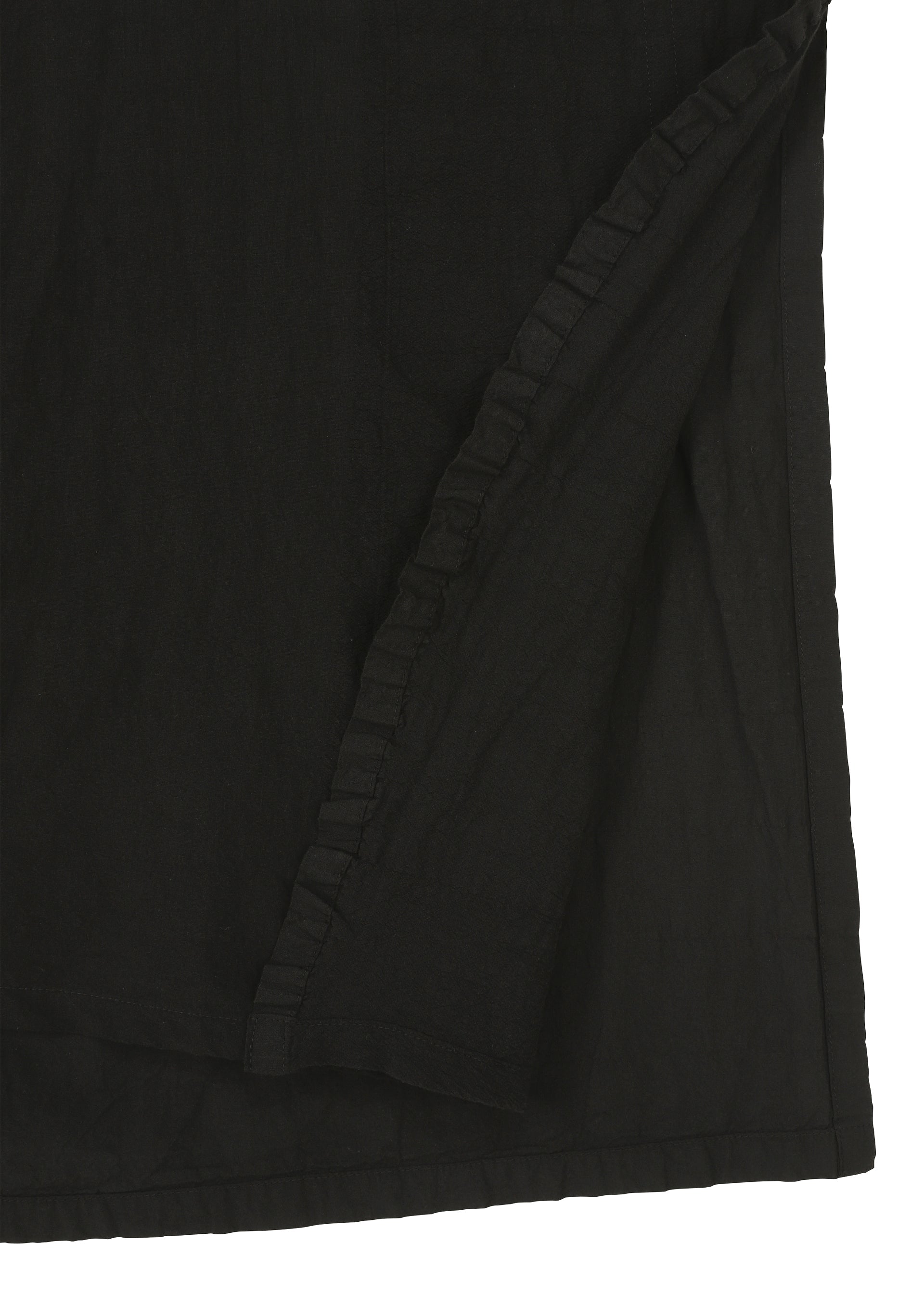 Zoomed view Close-up of TENMOKU COTTON by HaaT, a black fabric with a folded corner and ruffled edge. The smooth, subtly textured surface displays slight variations, reminiscent of garment-dyeing for added depth.